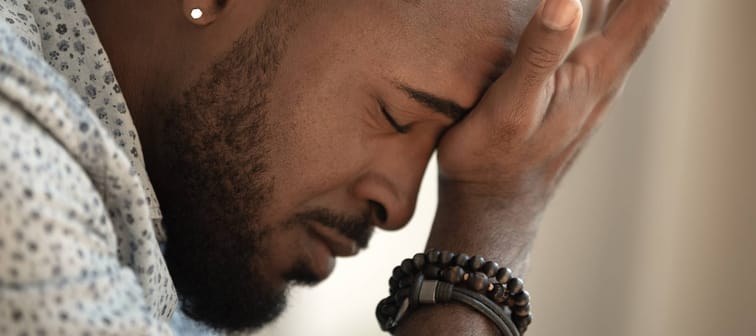 Younger Canadians worried about money. Man sits stressed.