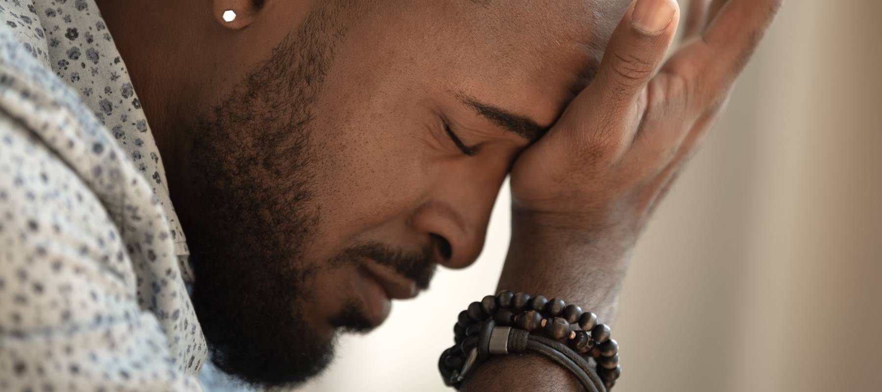 Younger Canadians worried about money. Man sits stressed.