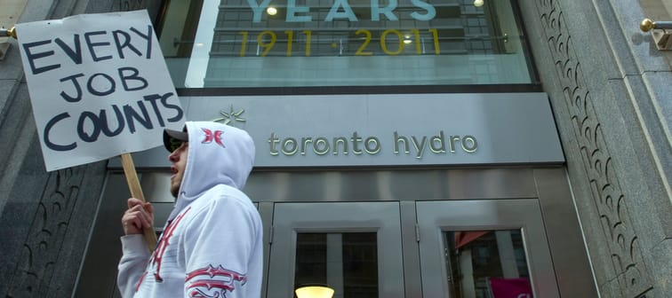 A protestor walks past the main doors of Toronto Hydro prior to impending layoffs. Feb 27, 2012.