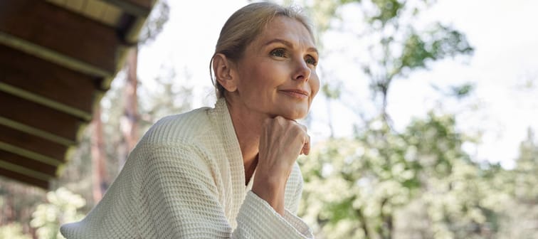 Older retired woman in dressing gown enjoying morning coffee