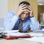 Frustrated middle aged businessman sitting at office desk