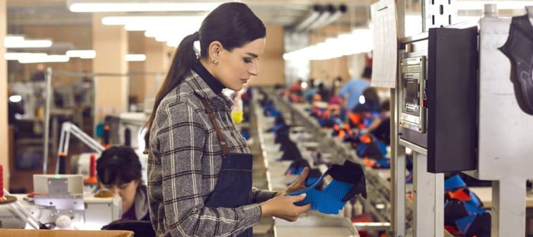 Woman in shoe factory observing shoes