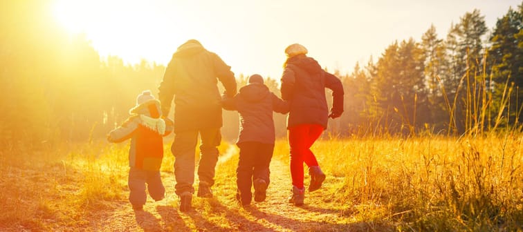 Happy family  running on country road in autumn time